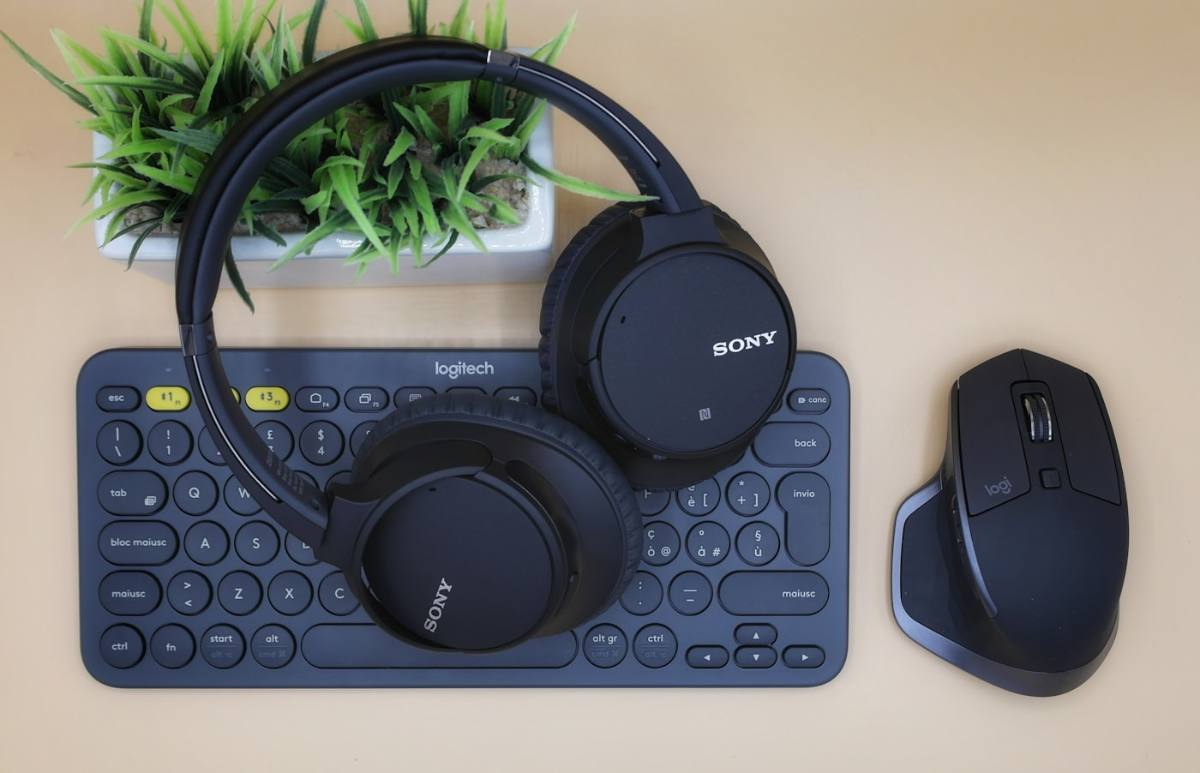Teclado, fone de ouvido e mouse organizados sobre mesa